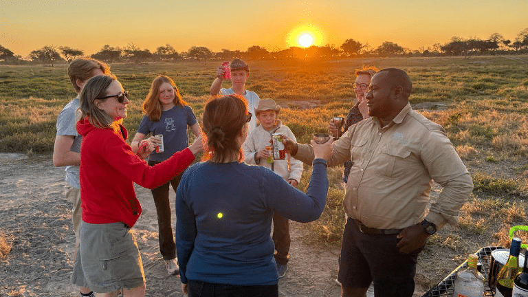 Guests enjoying a safari sundowner at sunset in Botswana